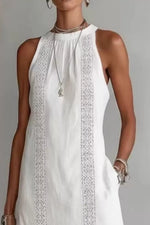 White sleeveless dress with intricate detailing on a plain background