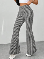 Houndstooth patterned pants worn by a person on a plain background