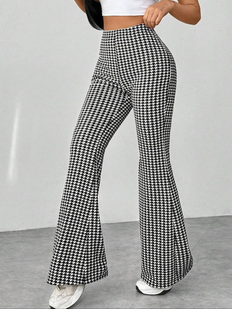 Houndstooth patterned pants worn by a person on a plain background