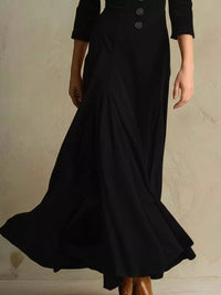 Black dress with a long skirt and three-quarter sleeves on a neutral background
