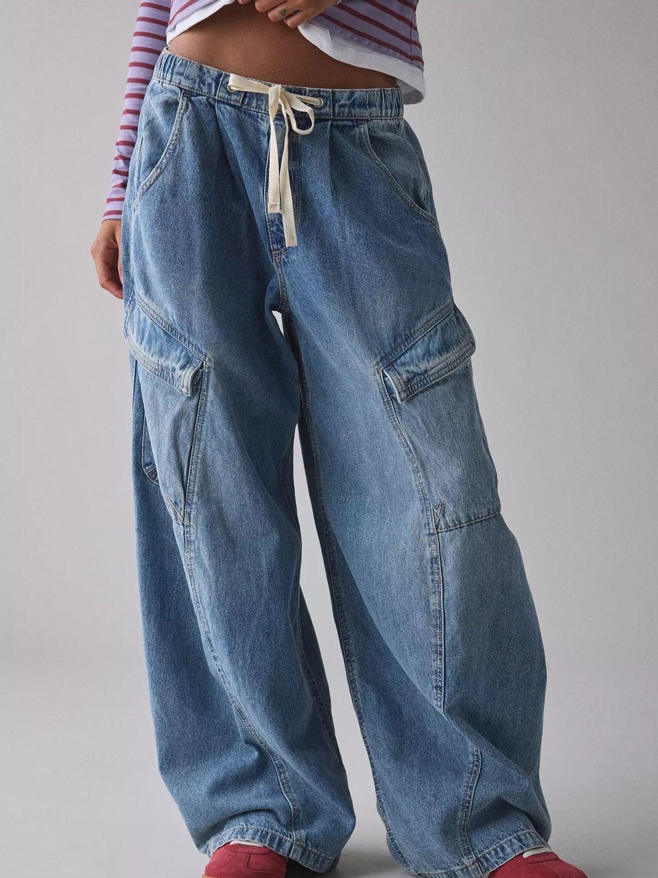 Person wearing blue baggy jeans on a plain background