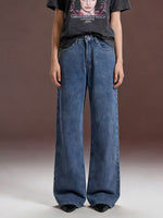 Person wearing wide-leg jeans and a graphic t-shirt on a plain background