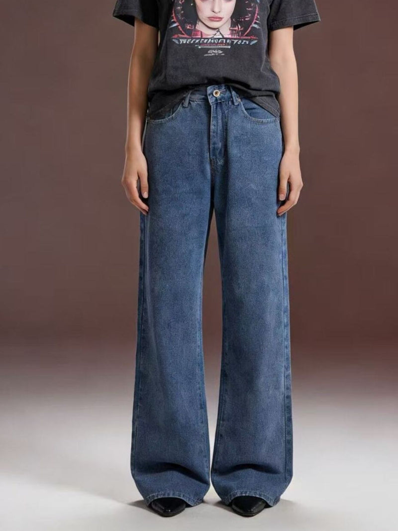 Person wearing wide-leg jeans and a graphic t-shirt on a plain background
