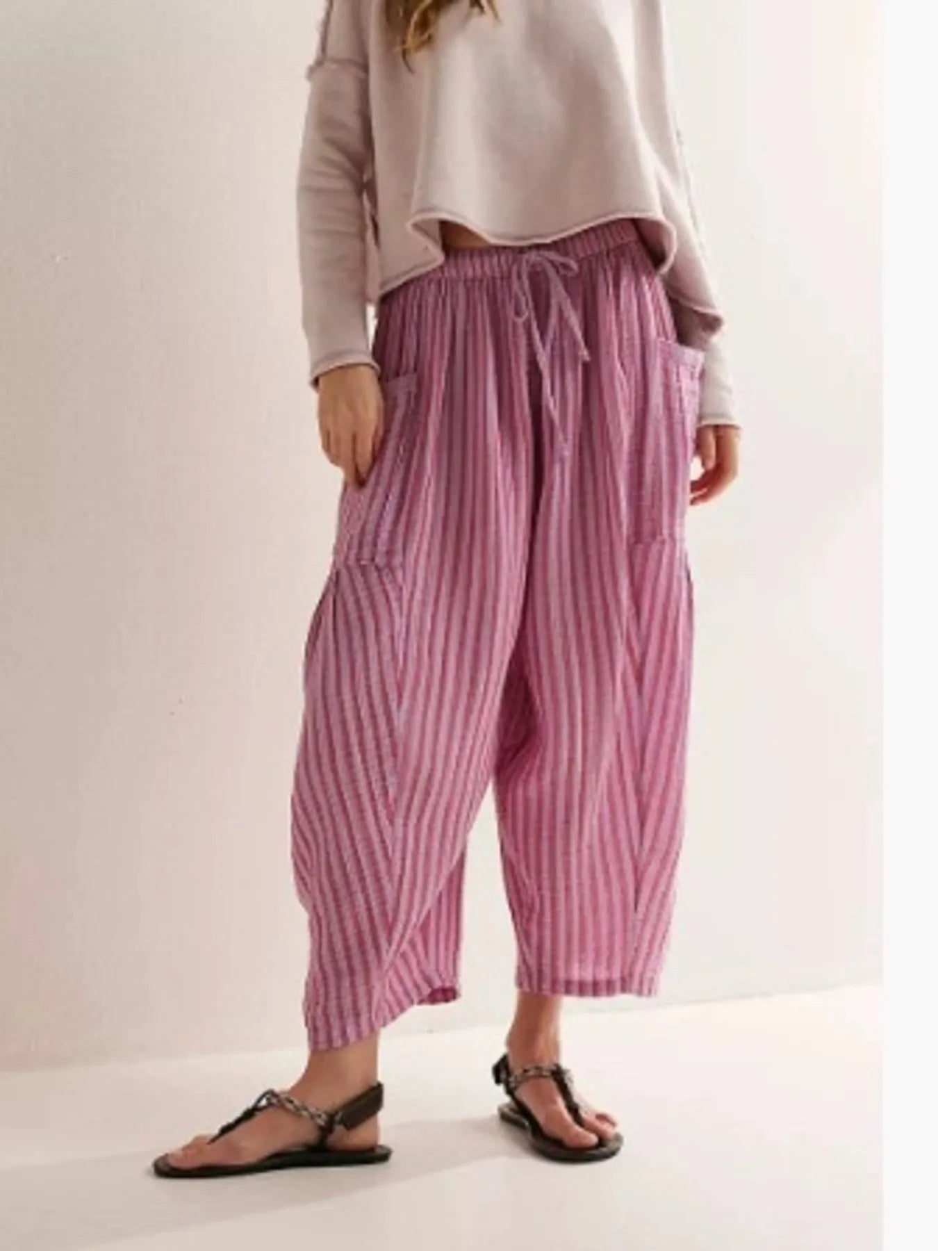 Person wearing pink striped pants on a plain background