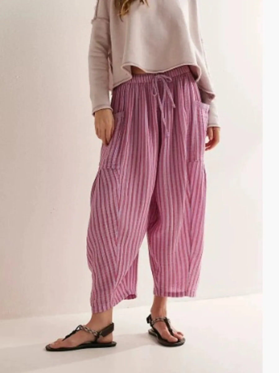 Person wearing pink striped pants on a plain background