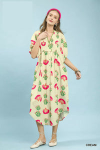 Woman wearing a cream-colored dress with floral pattern on a light blue background