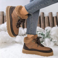 Brown winter boots with fur lining worn by a person in a snowy setting.
