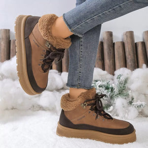 Brown winter boots with fur lining worn by a person in a snowy setting.