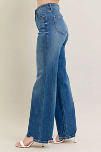 Blue jeans worn by a person on a plain background