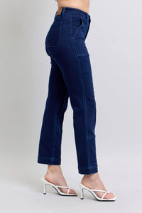 Navy blue jeans worn by a person on a light gray background