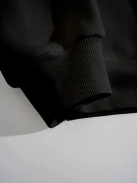 Black ribbed knit sweater on a white surface