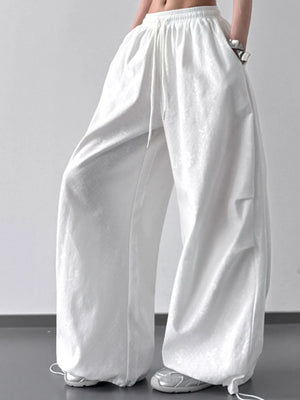 White wide-leg pants worn by a person on a plain background