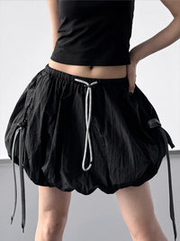 Black skirt with drawstring waist on a plain background