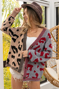 Woman wearing a patterned cardigan with a blurred outdoor background