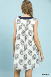 Woman wearing a sleeveless dress with floral pattern on a light blue background