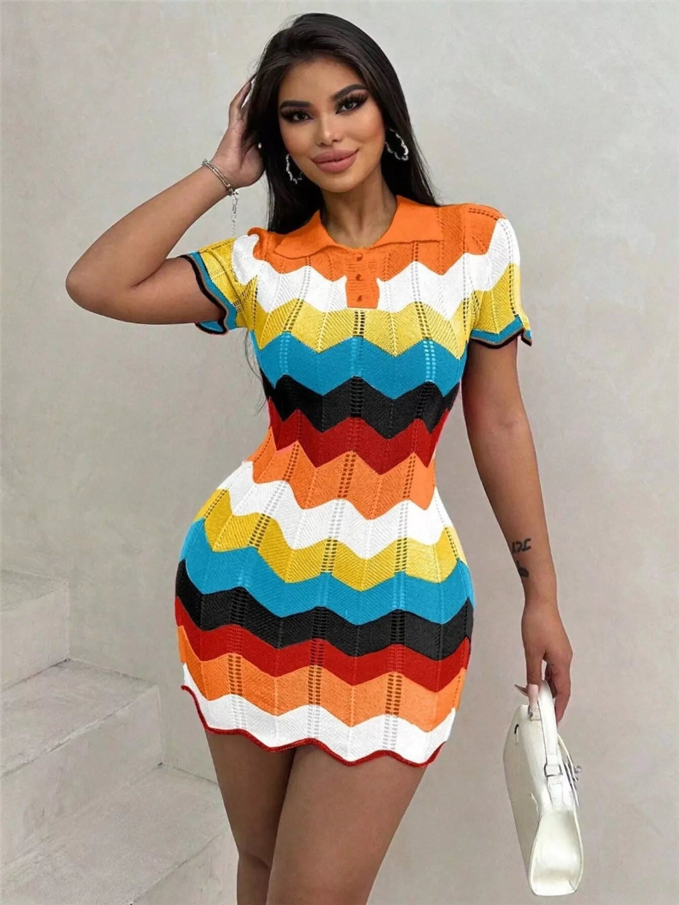 Woman wearing a colorful striped dress against a plain background