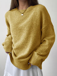 Person wearing a mustard yellow sweater against a plain background