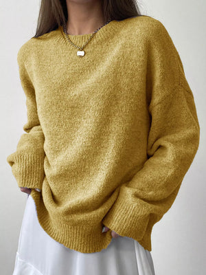 Person wearing a mustard yellow sweater against a plain background