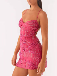 Pink embroidered dress worn by a model on a white background