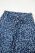 Blue pants with white leopard print pattern on a white background