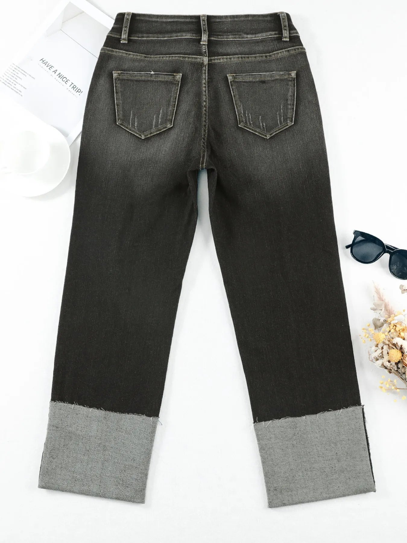 Black jeans with gray cuffs on a white background