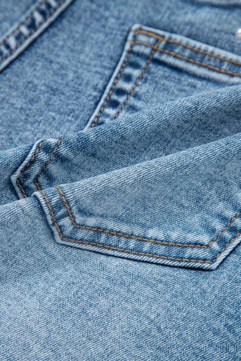 Close-up of blue denim fabric with stitching details