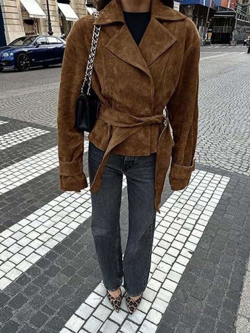 Person wearing a brown suede coat on a city street