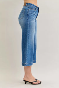 Blue jeans worn by a person on a plain background