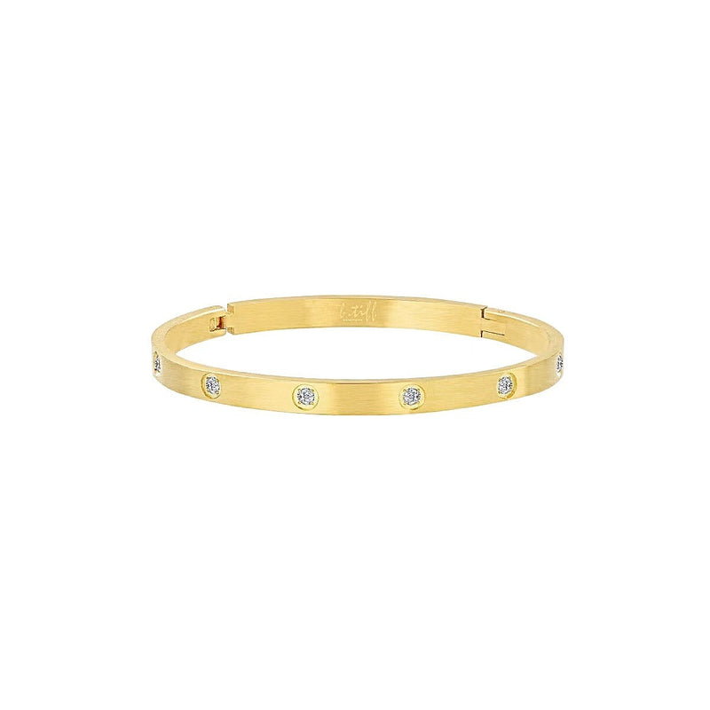 A matte gold bangle bracelet with eight stones arranged in a pattern around the band.