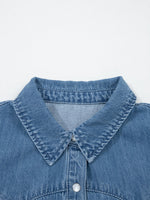 Close-up of a blue denim shirt collar on a light gray background