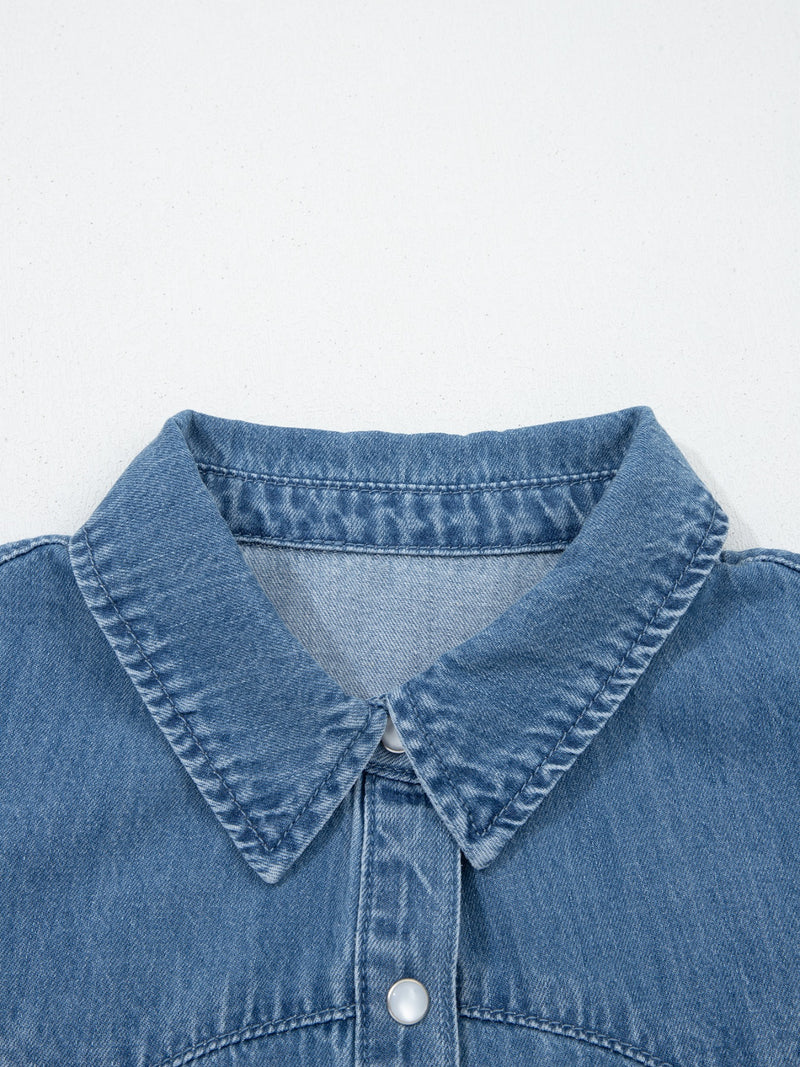 Close-up of a blue denim shirt collar on a light gray background