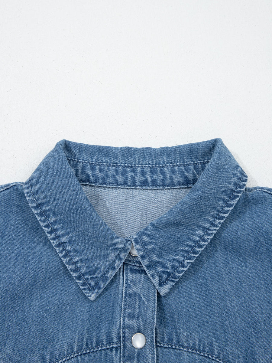 Close-up of a blue denim shirt collar on a light gray background