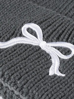 Gray textured fabric with a white embroidered bow design