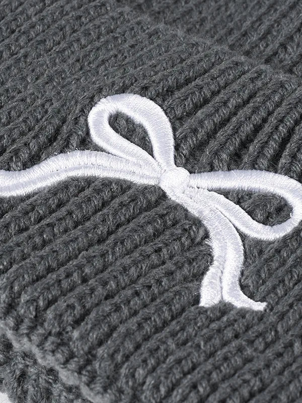 Gray textured fabric with a white embroidered bow design