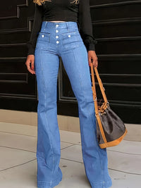 Person wearing blue jeans with white buttons, holding a brown handbag against a black background.
