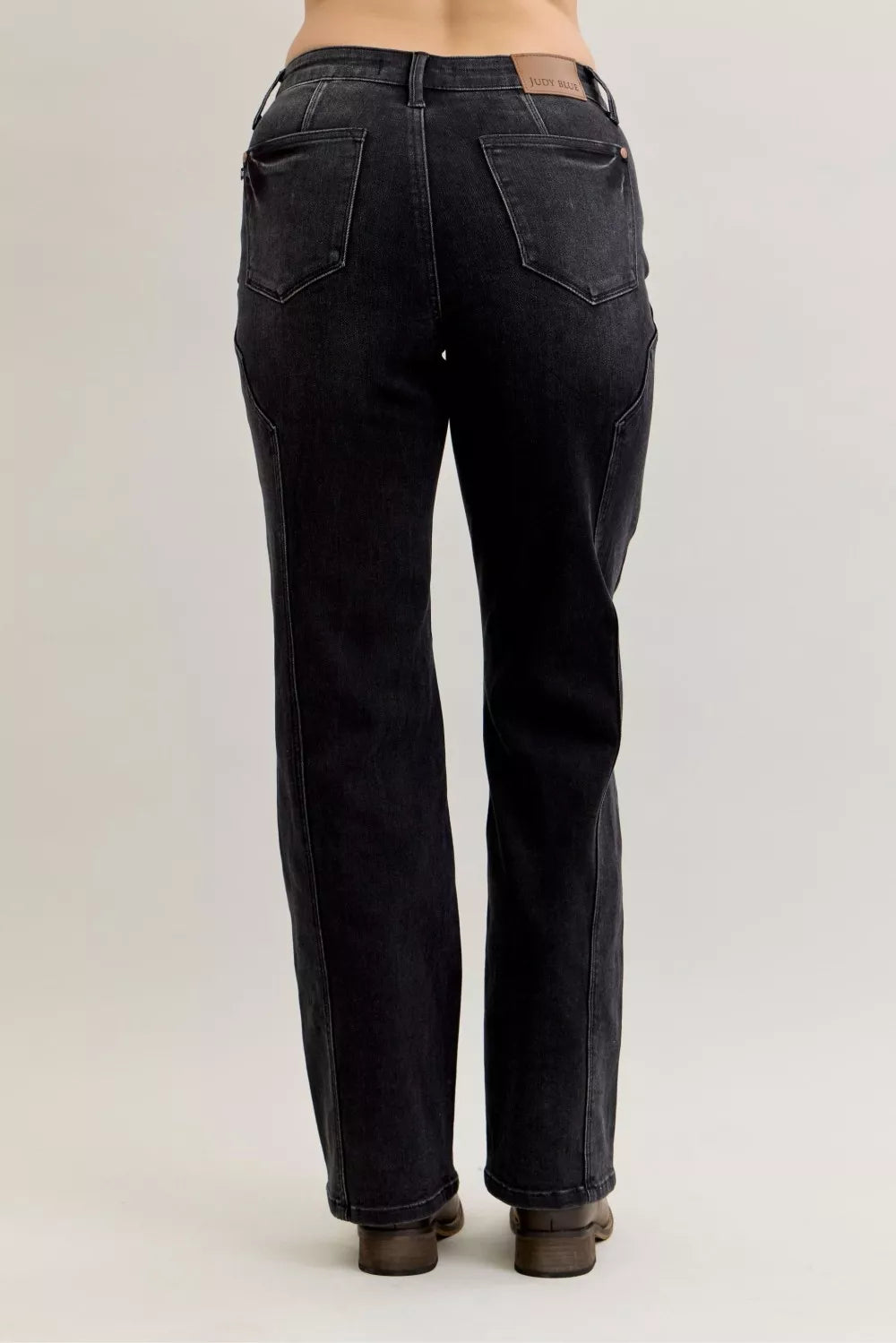 Black jeans worn by a person on a plain background