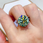 Ring with a large gemstone on a finger against a neutral background