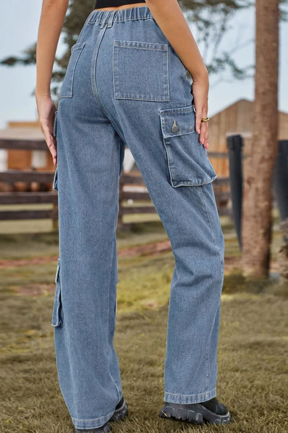 Person wearing blue cargo pants standing outdoors with a blurred background