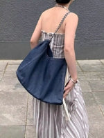Person holding a blue bag with a gray background