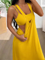 Woman wearing a yellow dress with a plunging neckline in an indoor setting.