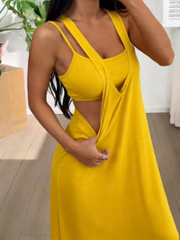 Woman wearing a yellow dress with a plunging neckline in an indoor setting.