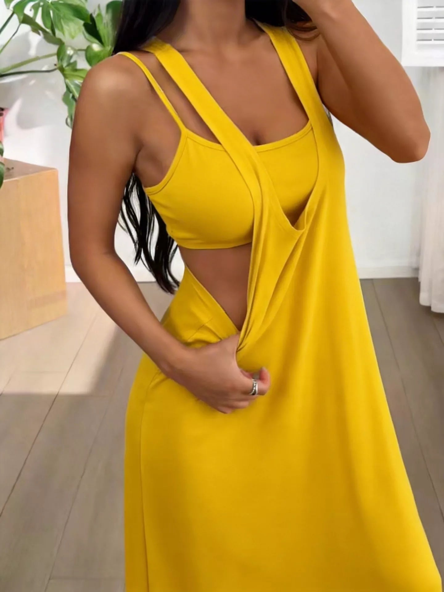 Woman wearing a yellow dress with a plunging neckline in an indoor setting.