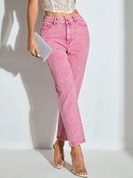 Person wearing pink jeans and a white lace top on a light background