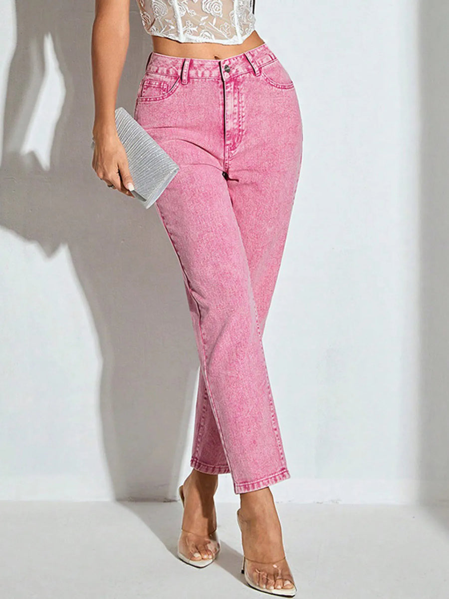 Person wearing pink jeans and a white lace top on a light background