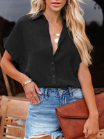 Woman wearing a black top and denim skirt, holding a brown clutch.