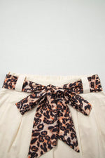 Leopard print belt with a bow on a light background