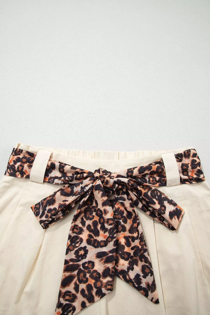 Leopard print belt with a bow on a light background