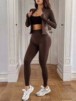 Woman wearing a brown athletic outfit with white sneakers in a room.