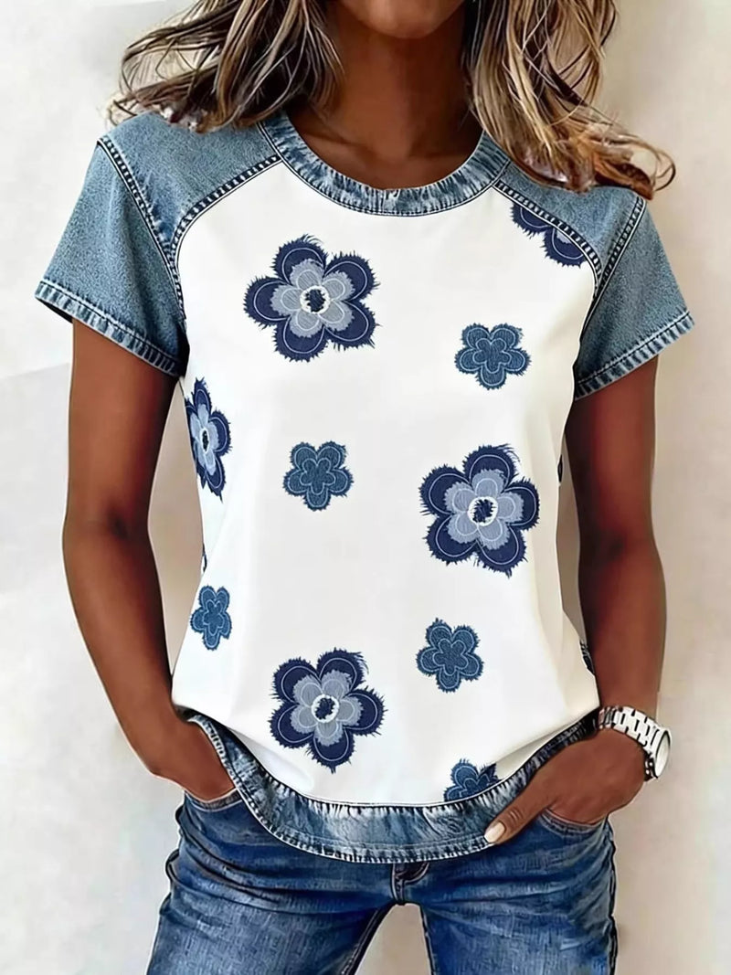 Woman wearing a white t-shirt with blue floral patterns and denim sleeves and pants.
