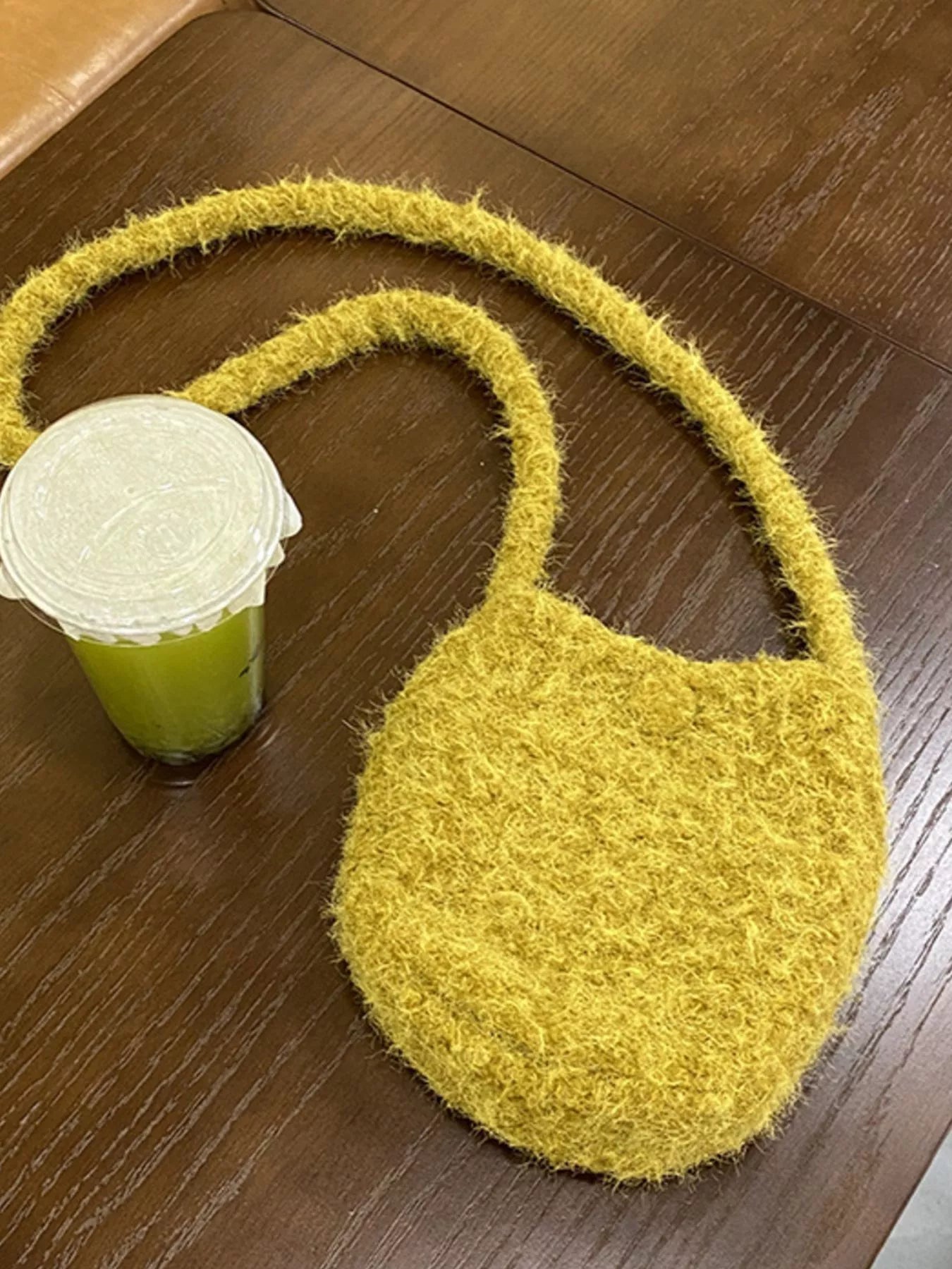 Yellow textured bag on a wooden surface with a green container next to it